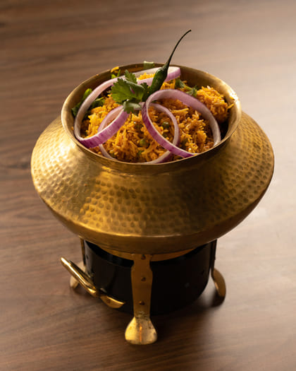 Biryani In a Pot with Onion Rings On It